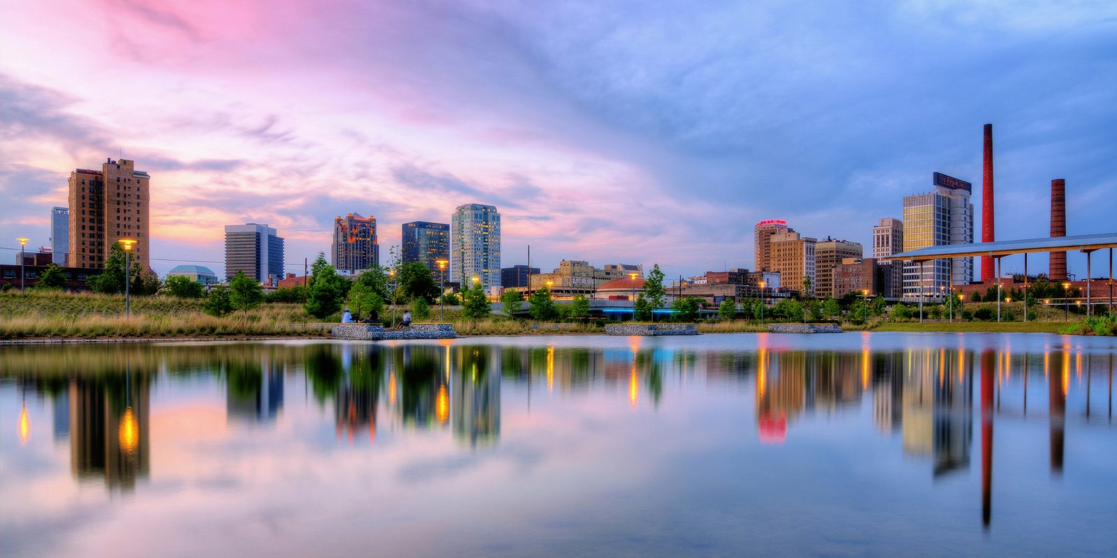 The Birmingham, Alabama skyline at sunset seen across the lake at Railroad Park